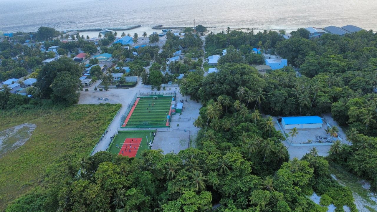 Aerial view of Innamaadhoo village, sports field, and harbor